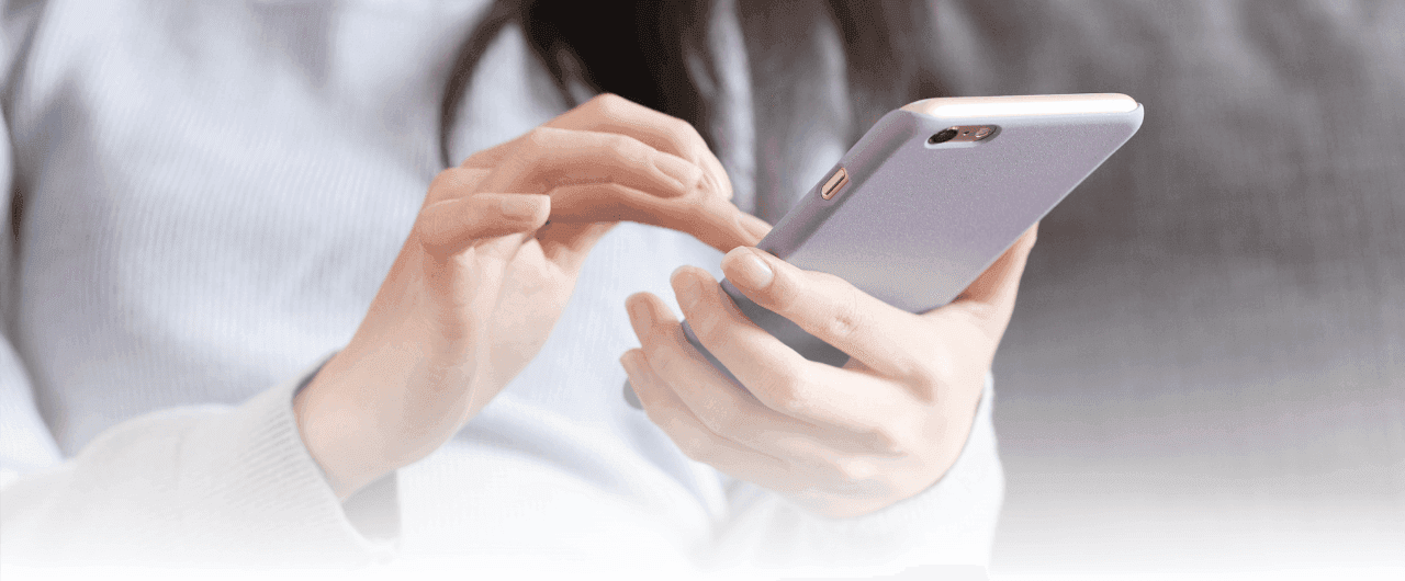 Frau mit grauem Pullover scrollt am Handy